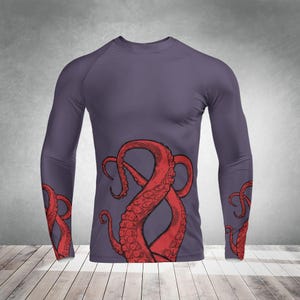 May include: A long-sleeved shirt with a purple base and a red octopus design. The octopus tentacles are on the sleeves and the torso of the shirt.