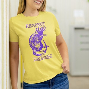 May include: A yellow t-shirt with a purple rat illustration and the text "RESPECT THE LOCALS".