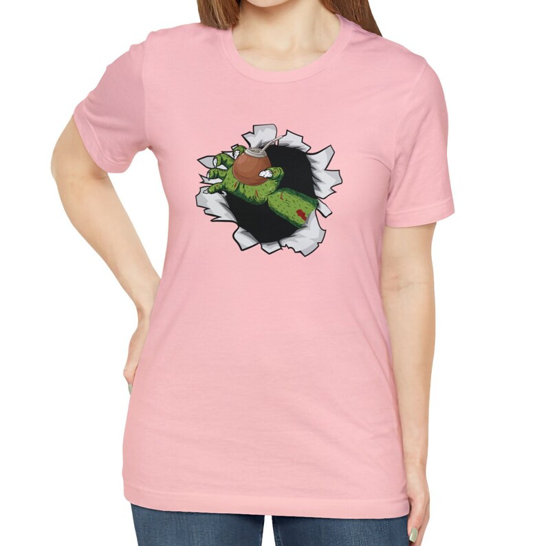 May include: A pink t-shirt with a graphic of a zombie hand reaching out of a ripped hole in the fabric, holding a brown gourd with a straw.