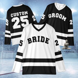 Pu&ograve; includere: Tre maglie da hockey, una bianca e due nere, con lettere e numeri bianchi. La maglia bianca dice "BRIDE" con il numero "2" e "5". Le maglie nere dicono "GROOM" e "CUSTOM" con il numero "25" e "2".
