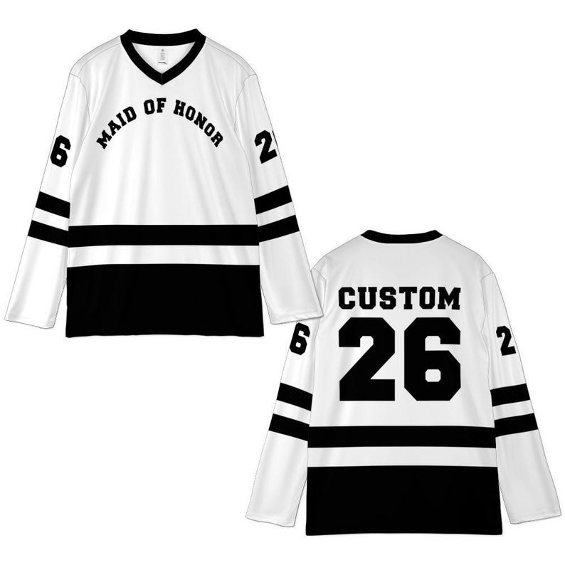 Pu&ograve; includere: Maglia da hockey bianca con strisce e dettagli neri. La parte anteriore recita "MAID OF HONOR" sopra una striscia nera, con i numeri "6" e "2" sulle maniche. La parte posteriore ha "CUSTOM" sopra il numero "26".