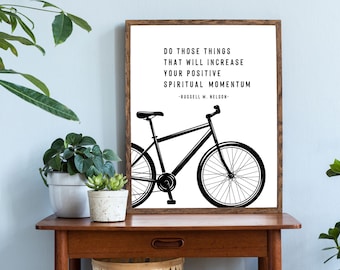 May include: A black and white motivational quote print featuring a bicycle silhouette and the text "Do those things that will increase your positive spiritual momentum - Russell M. Nelson - "