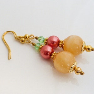 May include: Gold earrings with peach and pink beads and green glass beads.