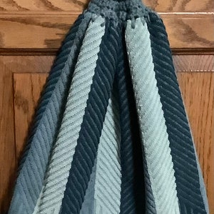 May include: Gray and white striped kitchen towel with a gray crocheted loop for hanging.