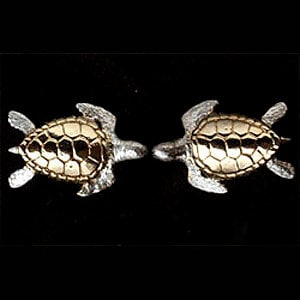 May include: A pair of silver earrings with a gold turtle design. The turtles have a detailed shell and are facing opposite directions.