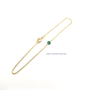 A Green Emerald bracelet features a faceted real Green Emerald that is centered on a 7" cable link SILVER or GOLD-FILLED dainty cable link chain. 
Bring flair to your style, wear it alone or layer it with chains from our collection.