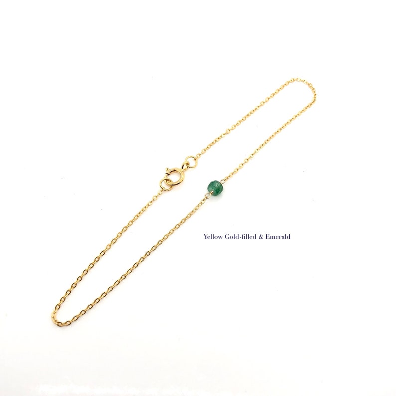 A Green Emerald bracelet features a faceted real Green Emerald that is centered on a 7" cable link SILVER or GOLD-FILLED dainty cable link chain. 
Bring flair to your style, wear it alone or layer it with chains from our collection.