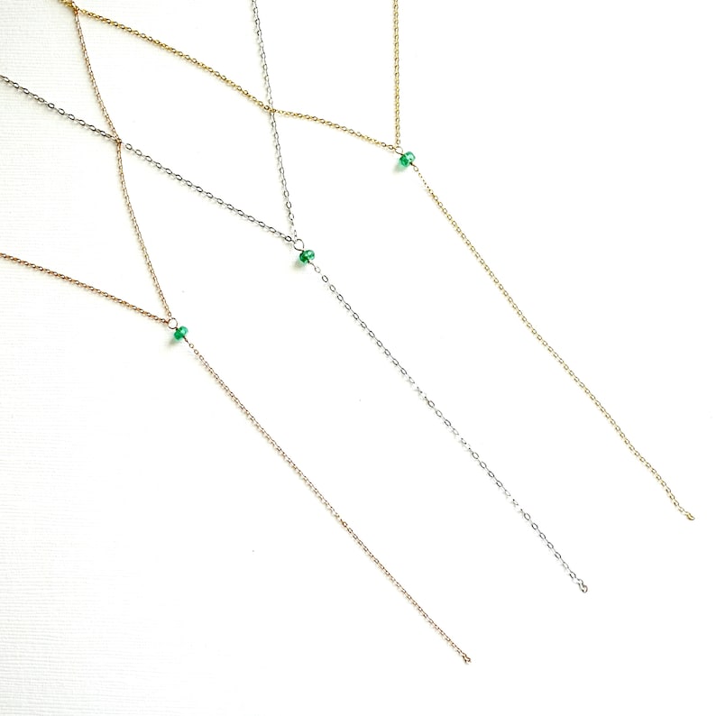 Pode incluir: Tr&ecirc;s colares delicados com um &uacute;nico pingente de pedra verde em cada um. Os colares s&atilde;o feitos de diferentes metais: ouro, prata e ouro rosa.