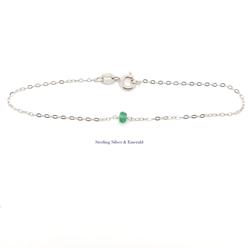 A Green Emerald bracelet features a faceted real Green Emerald that is centered on a 7" cable link SILVER or GOLD-FILLED dainty cable link chain. 
Bring flair to your style, wear it alone or layer it with chains from our collection.