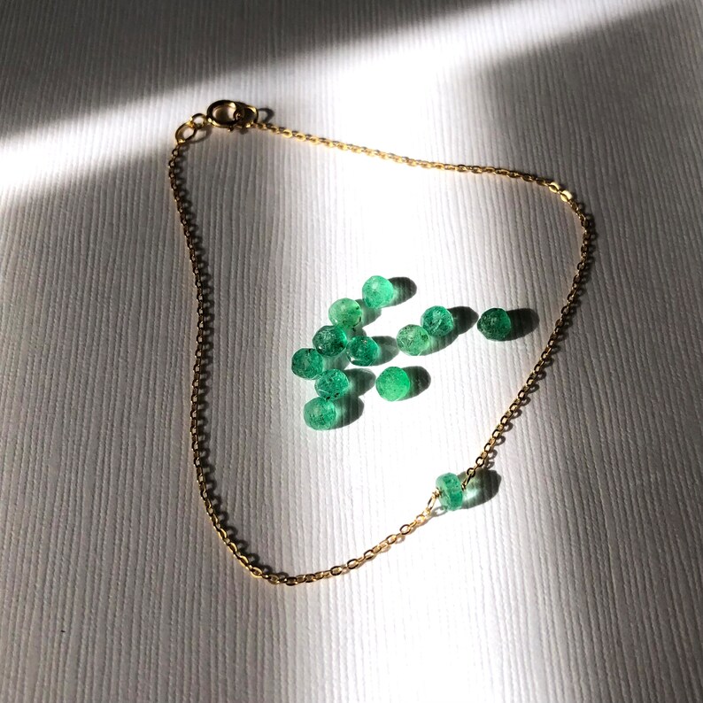 A Green Emerald bracelet features a faceted real Green Emerald that is centered on a 7" cable link SILVER or GOLD-FILLED dainty cable link chain. 
Bring flair to your style, wear it alone or layer it with chains from our collection.