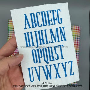 May include: A white fabric swatch with the alphabet embroidered in blue thread. The letters are in a serif font. The text "4 Sizes" and "PES DST EXP JEF PCS HUS SEW SHV VIP VP3 XXX" is printed below the alphabet.