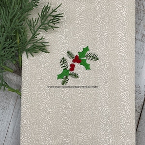 May include: A beige notebook with a white dotted pattern and a sprig of green holly with red berries embroidered on the cover. A sprig of green leaves is in the upper left corner. The text "www.etsy.com/shopaproverbs31wife" is at the bottom.