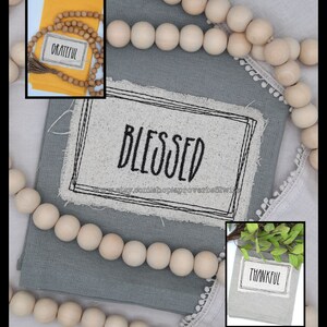 Puede incluir: Una composici&oacute;n decorativa con una tela gris con la palabra "BLESSED" en negro, enmarcada por un borde negro. Tambi&eacute;n hay cuentas de madera e im&aacute;genes m&aacute;s peque&ntilde;as con las palabras "GRATEFUL" y "THANKFUL".