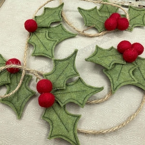 Può includere: Una ghirlanda di foglie di agrifoglio in feltro e bacche rosse in feltro infilate su uno spago. La ghirlanda è perfetta per aggiungere un tocco festivo alla tua decorazione domestica.