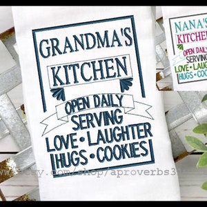 Könnte beinhalten: Ein weißes Küchentuch mit blauer Stickerei, auf dem "Grandma's Kitchen Open Daily Serving Love Laughter Hugs Cookies" steht.