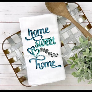 May include: White kitchen towel with teal blue embroidery that reads "home sweet home" with two hearts and a leafy branch.