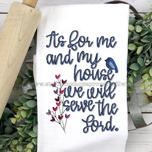 May include: White kitchen towel with blue embroidery that reads "As for me and my house we will serve the Lord." A small blue bird is embroidered above the text and a branch with pink hearts is embroidered to the left of the text.