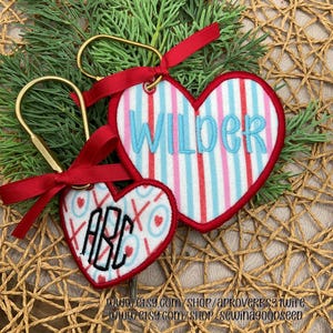 May include: A set of three ceramic mugs with a speckled, cream-colored glaze. Each mug features a different hand-painted floral design in shades of blue, green, and yellow. The mugs have a simple, modern shape.