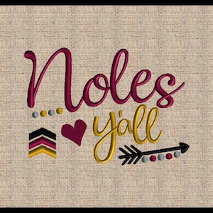 Puede incluir: Diseño bordado sobre un fondo de tela beige. El diseño presenta las palabras "Noles y'all" en letras burdeos y doradas con un corazón y una flecha.