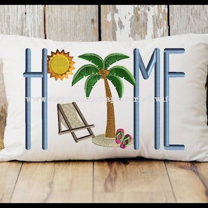 Könnte beinhalten: Weißes Kissen mit blauer Stickerei des Wortes "HOME" mit einer Palme, Sonne, Liegestuhl und Flip-Flops in der Mitte.