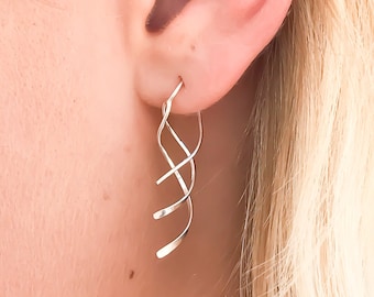 May include: Silver dangle earrings with a twisted wire design.