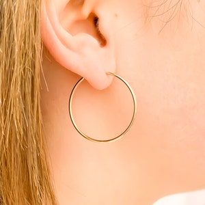 May include: A pair of gold hoop earrings. The earrings are simple and elegant, and they would be a great addition to any jewelry collection.