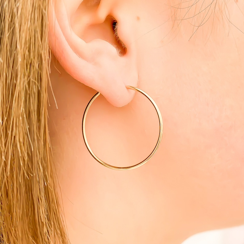 May include: A pair of gold hoop earrings. The earrings are simple and elegant, and they would be a great addition to any jewelry collection.