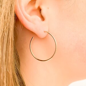 May include: A pair of gold hoop earrings. The earrings are simple and elegant, and they would be a great addition to any jewelry collection.