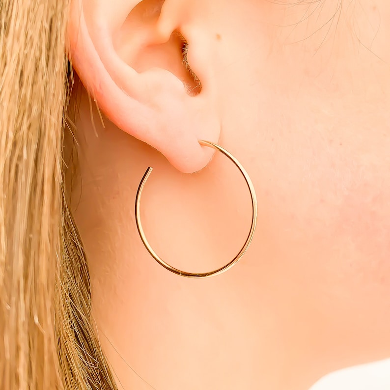 May include: A pair of gold hoop earrings. The earrings are simple and elegant, and they would be a great addition to any jewelry collection.