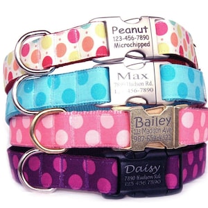 May include: Four dog collars with personalized tags. The collars are pink, purple, blue, and white with pink polka dots. The tags are silver and gold with black text. The text on the tags includes the dog's name, address, and phone number.  The collars are made of a soft, durable material and are perfect for everyday wear.