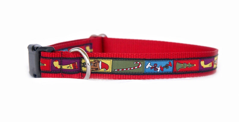 Puede incluir: Collar rojo para perro con hebilla de pl&aacute;stico negro y anilla en D de metal plateado. El collar presenta un patr&oacute;n repetido de im&aacute;genes con tem&aacute;tica navide&ntilde;a, que incluyen un perro con gorro de Pap&aacute; Noel, un bast&oacute;n de caramelo y un &aacute;rbol de Navidad.