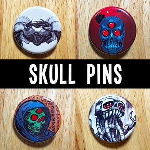 Peut inclure: Quatre boutons de pin à thème crâne. Les boutons sont ronds et présentent différents motifs de crânes. Un bouton a un crâne noir et blanc avec un troisième œil, un autre a un crâne rouge et bleu avec trois yeux, un autre a un crâne vert avec trois yeux et une figure à capuchon, et le dernier bouton a un crâne gris avec des tentacules.