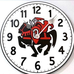 May include: A white clock face with black numbers 1 through 12. The clock has black hands and a red and black logo of a knight riding a horse. The logo has a white letter "O" in the center.