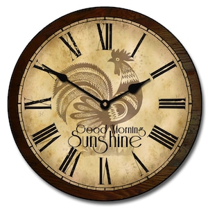 May include: A round wooden clock with a rooster design and the text "Good Morning Sunshine". The clock face is cream colored with black Roman numeral hour markers and black hands.