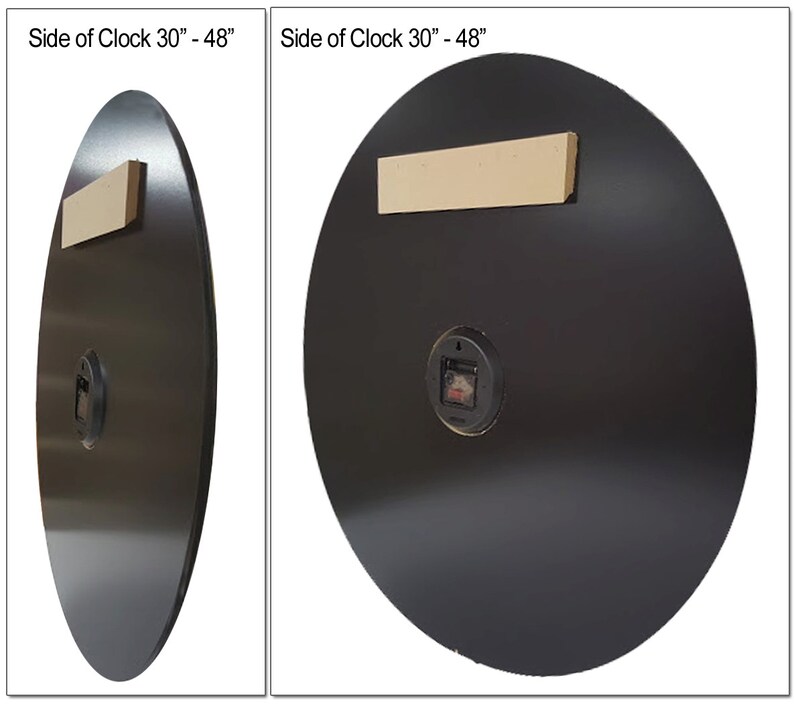 May include: Back view of a black round clock with a diameter of 30 inches. The clock has a white wooden hanging bracket and a small black clock mechanism.