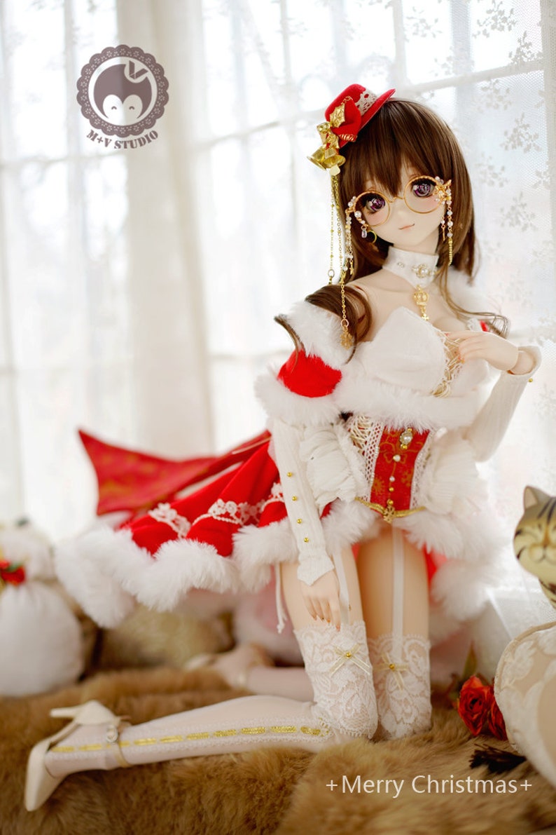 May include: A doll wearing a red and white Christmas dress with a white fur trim, a red hat with gold bells, and white lace stockings. The doll has brown hair and is wearing round glasses. The doll is sitting on a furry surface with a red rose in the background. +Merry Christmas+