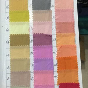 May include: A color chart with fabric swatches in various shades of yellow, beige, pink, purple, orange, and red. The swatches are numbered with the numbers 577, 576, 575, 574, 573, 572, 571, 570, 569, 568, 567, 566, 565, 564, 563, 562, 561, 560, 559, 558, 557, 556, 555, 554.