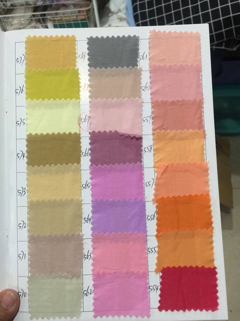 May include: A color chart with fabric swatches in various shades of yellow, beige, pink, purple, orange, and red. The swatches are numbered with the numbers 577, 576, 575, 574, 573, 572, 571, 570, 569, 568, 567, 566, 565, 564, 563, 562, 561, 560, 559, 558, 557, 556, 555, 554.