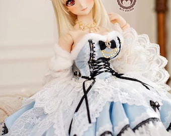 May include: A doll wearing a blue and white dress with black lace trim and a gold crown. The doll has long blonde hair and red eyes.