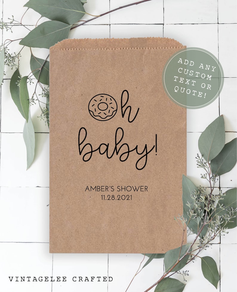 May include: A brown paper bag with a donut and the text "oh baby!" printed on it. The bag also includes the text "Amber's Shower 11.28.2021" and "Add any custom text or quote!"