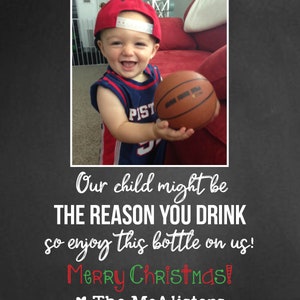 May include: A young child wearing a red baseball cap and a blue and white jersey holds a basketball. The text "Our child might be THE REASON YOU DRINK so enjoy this bottle on us! Merry Christmas! The McAlisters" is written below the image.