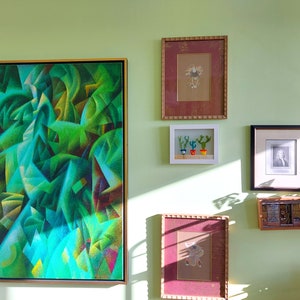 K&ouml;nnte beinhalten: Eine Wandgalerie mit verschiedenen gerahmten Kunstwerken, darunter ein gro&szlig;es abstraktes Gem&auml;lde in Gr&uuml;n- und Blaut&ouml;nen, ein gerahmter Druck mit rotem Rahmen, ein kleiner gerahmter Druck mit drei Topfkakteen, ein gerahmtes Schwarzwei&szlig;foto und ein gerahmter Druck aus Holz mit geometrischem Muster.