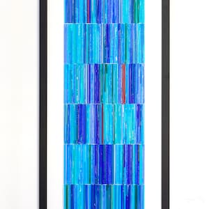 May include: A framed abstract artwork featuring a mosaic of blue, turquoise, and red glass pieces arranged in vertical lines.