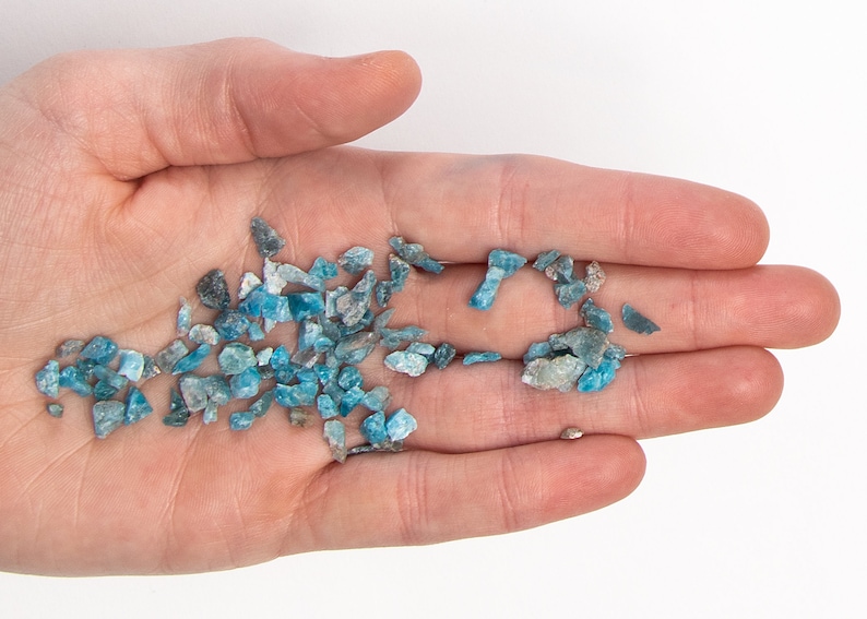 May include: A handful of small, blue-green gemstone chips. The chips are irregular in shape and have a slightly translucent appearance.
