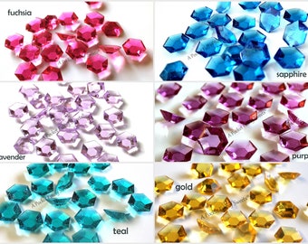 May include: Assortment of colourful, faceted, hexagonal glass gems in fuchsia, lavender, sapphire, teal, gold, and purple.