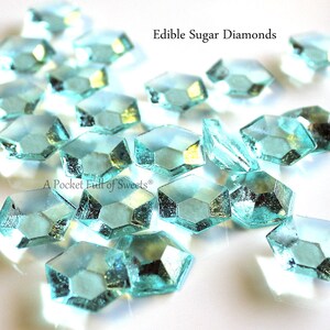 Peut inclure: Gros plan sur des diamants de sucre comestibles bleu turquoise sur une surface blanche. Le texte "Edible Sugar Diamonds" est visible en haut de l'image.