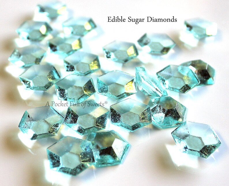 Peut inclure: Gros plan sur des diamants de sucre comestibles bleu turquoise sur une surface blanche. Le texte "Edible Sugar Diamonds" est visible en haut de l'image.