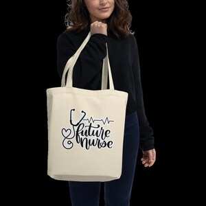 May include: A beige tote bag with a black and white design featuring a stethoscope, a heart, and the text "future nurse".