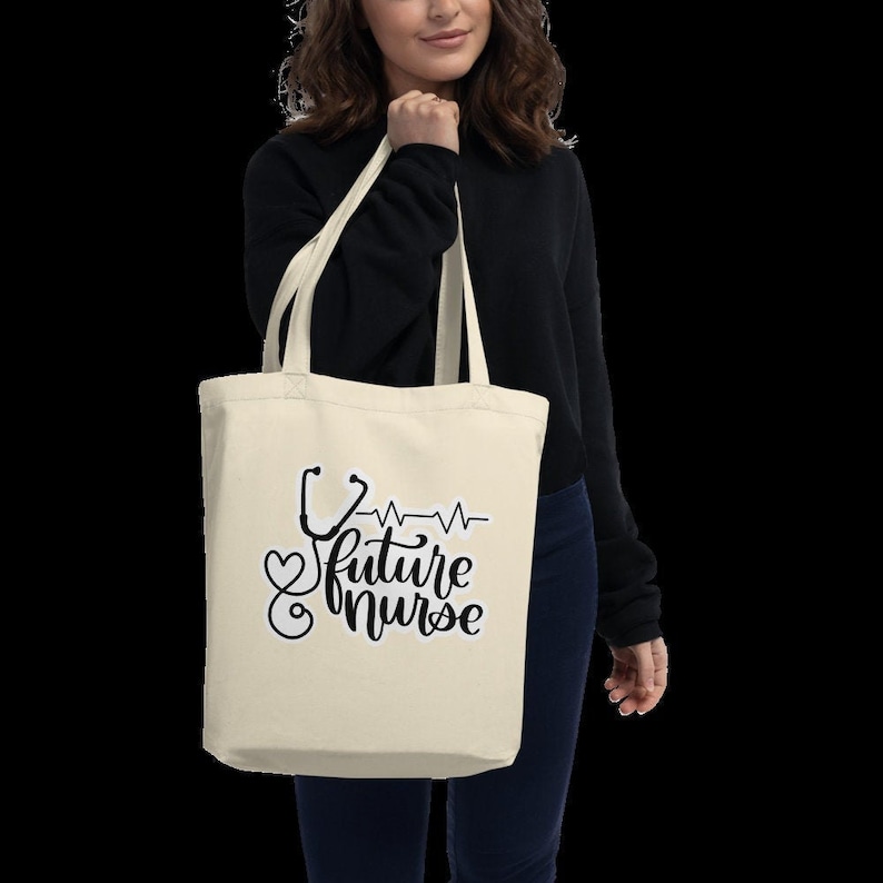 May include: A beige tote bag with a black and white design featuring a stethoscope, a heart, and the text "future nurse".