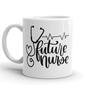 May include: White ceramic coffee mug with a black design of a stethoscope, a heart, and the text "future nurse" with a heartbeat line.